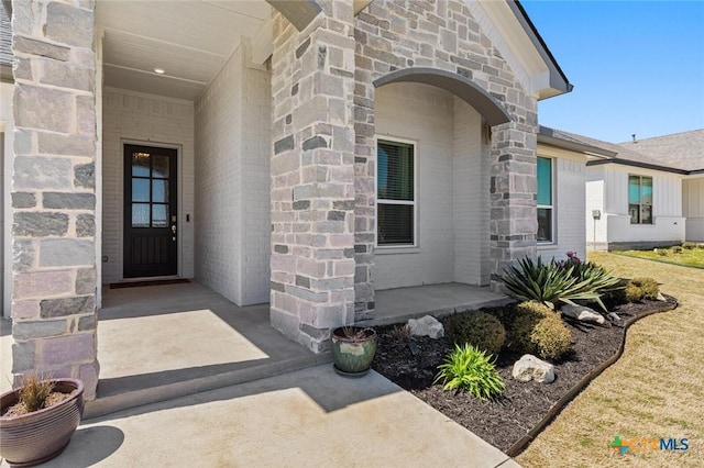 doorway to property with stone siding and brick siding