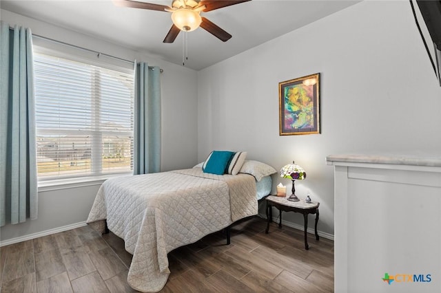 bedroom with baseboards, wood finished floors, and a ceiling fan