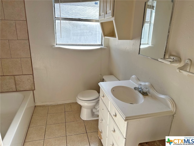 bathroom with toilet, vanity, and tile patterned floors