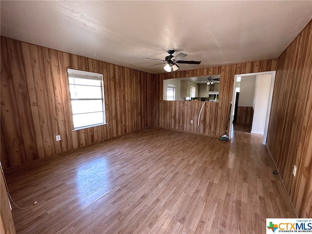 empty room featuring wooden walls and wood-type flooring