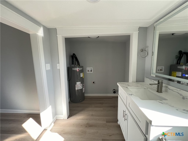 bathroom featuring electric water heater, vanity, and hardwood / wood-style flooring