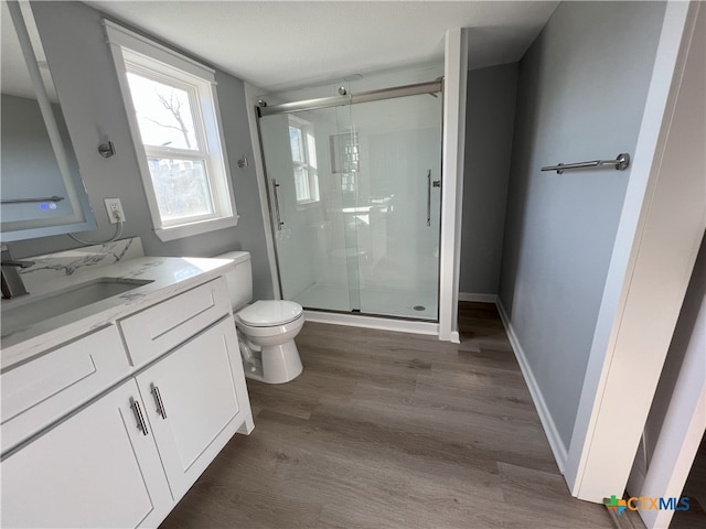 bathroom with vanity, toilet, wood-type flooring, and walk in shower