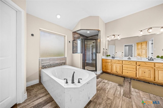 1117 Myrtle Dr, Copperas Cove, TX 76522 - full bathroom with a stall shower, double vanity, a garden tub, vaulted ceiling, and wood finished floors
