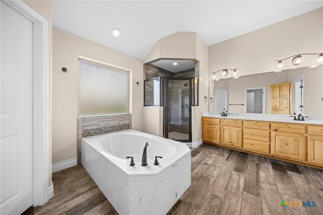 1117 Myrtle Dr, Copperas Cove, TX 76522 - bathroom featuring a stall shower, double vanity, a bath, wood finished floors, and vaulted ceiling