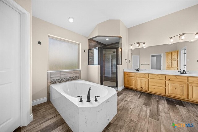 1117 Myrtle Dr, Copperas Cove, TX 76522 - bathroom featuring a stall shower, double vanity, a bath, wood finished floors, and vaulted ceiling