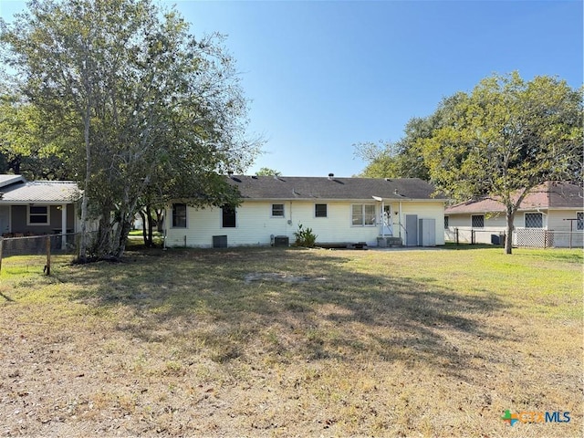 rear view of house featuring a lawn and central air condition unit