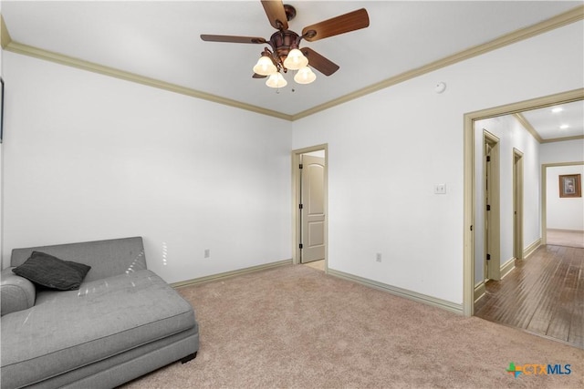 living area with carpet flooring, crown molding, and ceiling fan