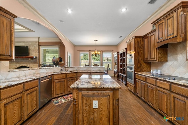 kitchen with light stone countertops, dishwasher, dark hardwood / wood-style floors, a chandelier, and a kitchen island