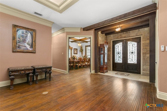 foyer entrance with hardwood / wood-style flooring, ornamental molding, beamed ceiling, and french doors