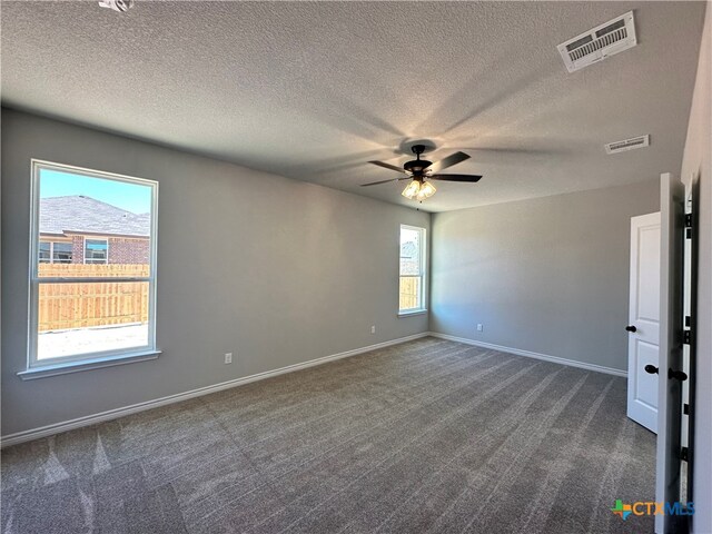 carpeted empty room with ceiling fan and a textured ceiling