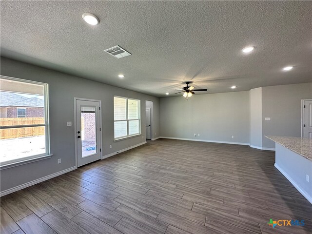 unfurnished living room with hardwood / wood-style floors, ceiling fan, and a textured ceiling