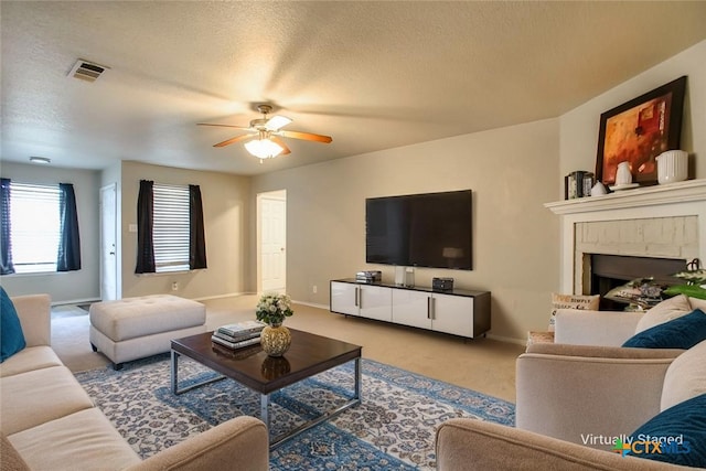3903 Kevin Shaw Dr, Killeen, TX 76549 - living room with carpet floors, ceiling fan, a fireplace, and a textured ceiling