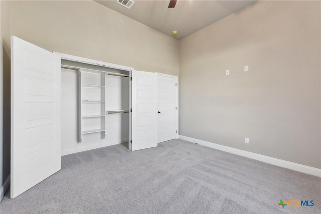 unfurnished bedroom with light carpet, a closet, and ceiling fan