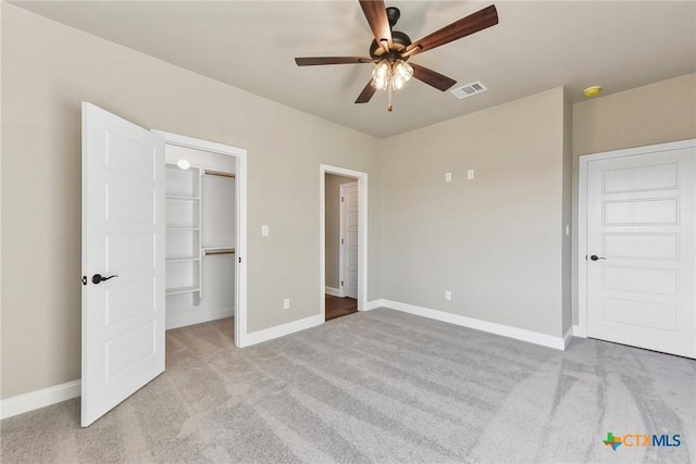 unfurnished bedroom featuring ceiling fan, light colored carpet, and a closet