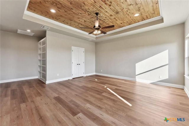 unfurnished room with a tray ceiling, crown molding, wooden ceiling, and wood-type flooring