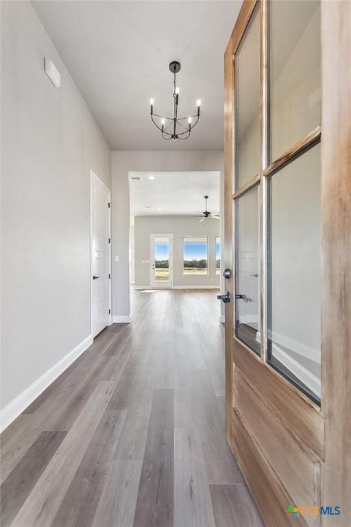 corridor featuring hardwood / wood-style floors and a notable chandelier