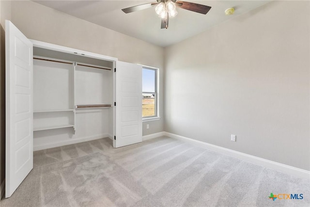 unfurnished bedroom featuring light carpet, a closet, and ceiling fan