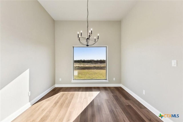 unfurnished dining area featuring dark hardwood / wood-style flooring and a chandelier