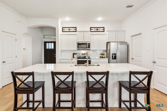 2619 Settlers Oak Dr, Belton, TX 76513 - kitchen with decorative backsplash, visible vents, appliances with stainless steel finishes, arched walkways, and a sink
