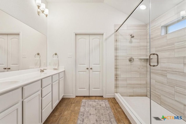 2619 Settlers Oak Dr, Belton, TX 76513 - bathroom with double vanity, wood finished floors, a sink, a stall shower, and vaulted ceiling