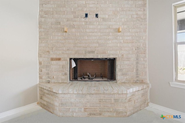 details featuring a brick fireplace and baseboards