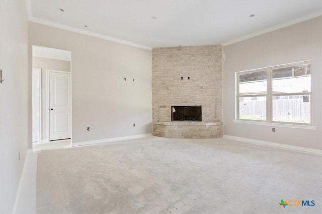 unfurnished living room featuring carpet floors, ornamental molding, a brick fireplace, and baseboards