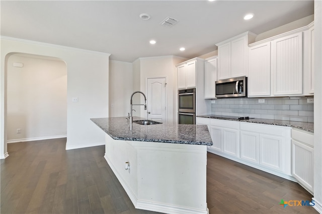 kitchen featuring dark hardwood / wood-style flooring, a center island with sink, sink, white cabinetry, and appliances with stainless steel finishes