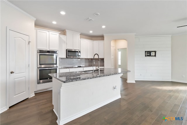 kitchen featuring an island with sink, white cabinetry, sink, and appliances with stainless steel finishes