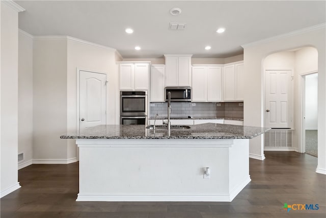 kitchen featuring dark stone countertops, appliances with stainless steel finishes, and white cabinets