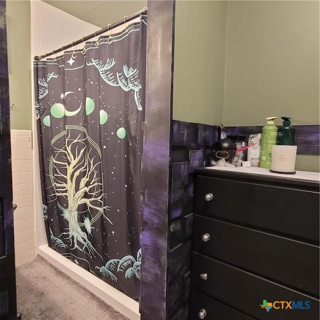 706 S 1st St, Copperas Cove, TX 76522 - bathroom with vanity, a shower with shower curtain, tile walls, and wainscoting