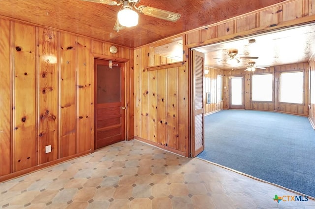 spare room with wood ceiling, ceiling fan, and wooden walls