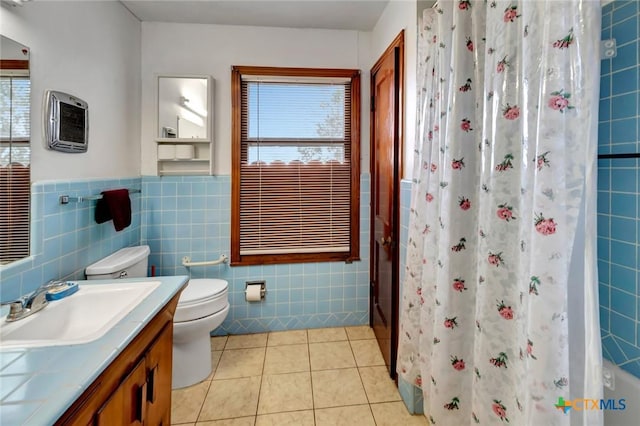 bathroom featuring tile walls, vanity, tile patterned floors, toilet, and walk in shower