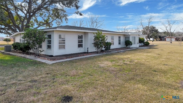 view of front of home with central AC and a front yard