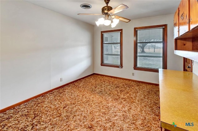 unfurnished dining area featuring carpet floors and ceiling fan