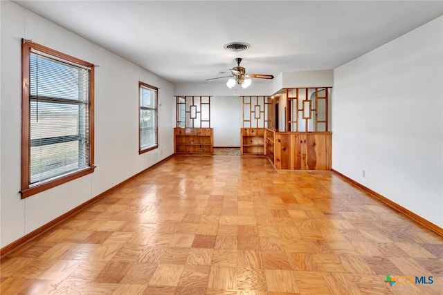 unfurnished room with ceiling fan and light parquet flooring