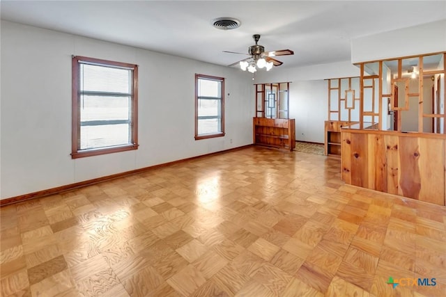 empty room with ceiling fan and light parquet flooring