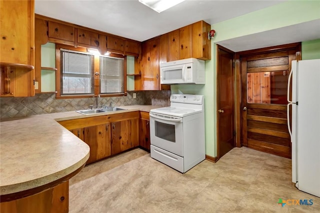 kitchen with tasteful backsplash, white appliances, and sink