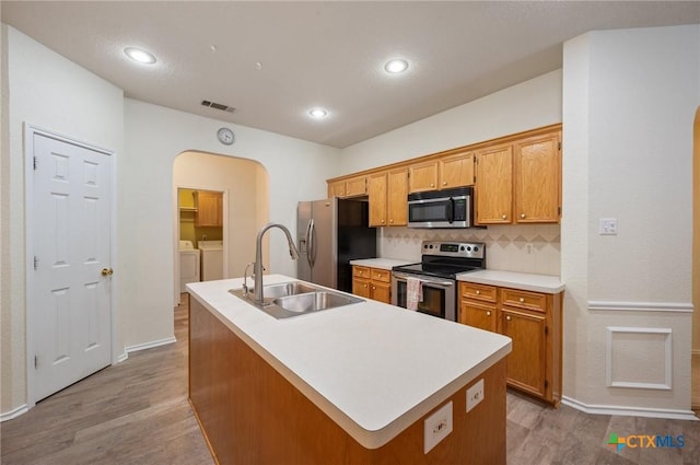 104 Missouri Dr, Harker Heights, TX 76548 - kitchen with stainless steel appliances, independent washer and dryer, arched walkways, a sink, and wood finished floors