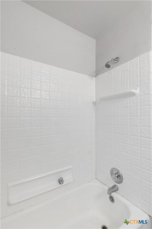 bathroom featuring tiled shower / bath