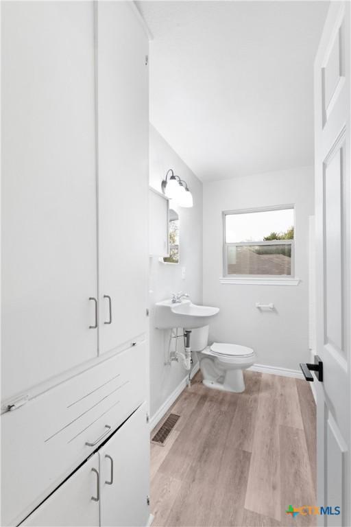 bathroom featuring toilet and wood-type flooring