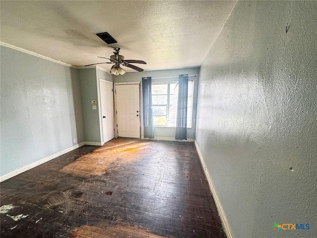 unfurnished room featuring ceiling fan, wood-type flooring, and a textured ceiling