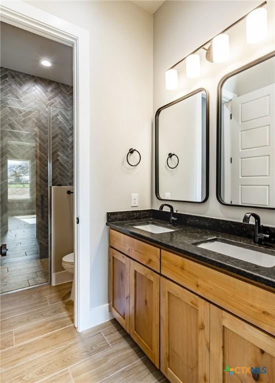 104 Hondo Vis, La Vernia, TX 78121 - bathroom featuring double vanity, a shower stall, and wood finished floors