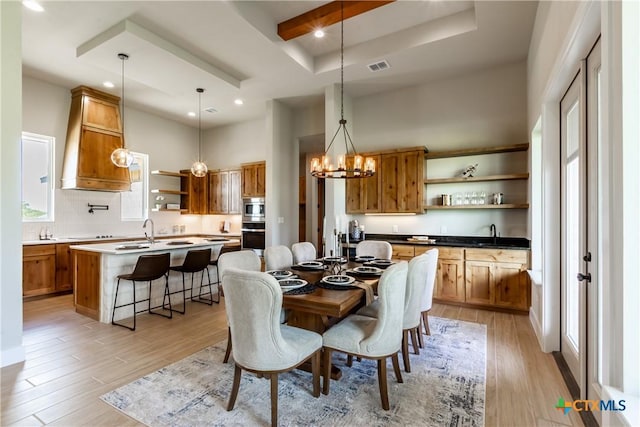 104 Hondo Vis, La Vernia, TX 78121 - dining room featuring a tray ceiling, light wood-type flooring, a high ceiling, a chandelier, and recessed lighting