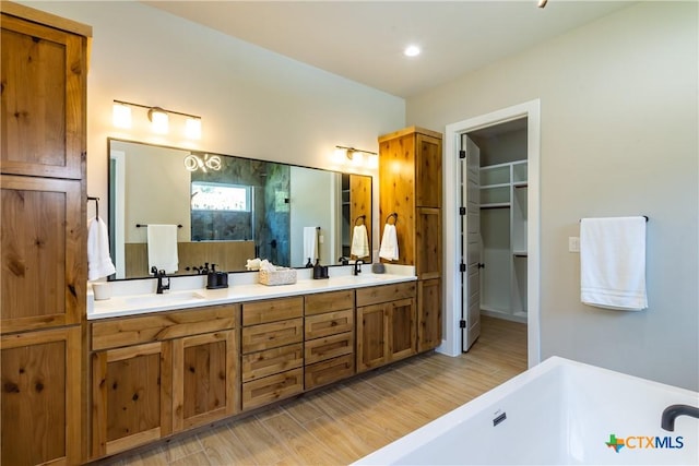 104 Hondo Vis, La Vernia, TX 78121 - full bath featuring a freestanding tub, double vanity, wood finished floors, a spacious closet, and a shower