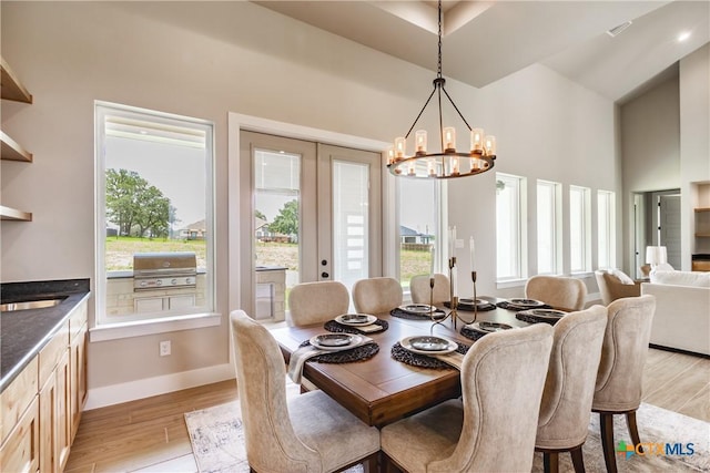 104 Hondo Vis, La Vernia, TX 78121 - dining area featuring a towering ceiling, a chandelier, healthy amount of natural light, and light wood-style flooring