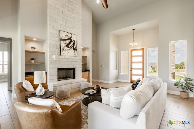 104 Hondo Vis, La Vernia, TX 78121 - living room featuring high vaulted ceiling, healthy amount of natural light, built in shelves, and a stone fireplace