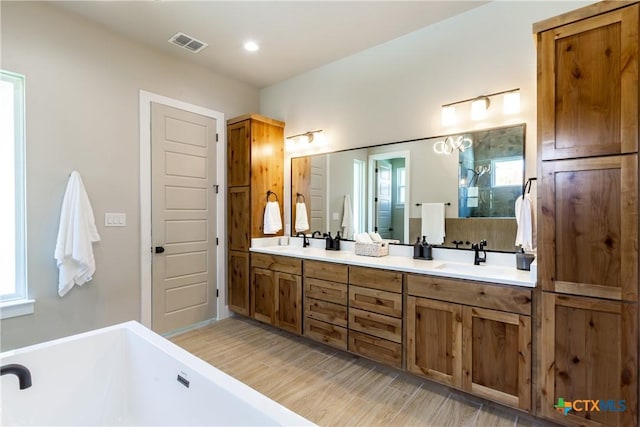 104 Hondo Vis, La Vernia, TX 78121 - bathroom featuring a soaking tub, double vanity, wood finished floors, and recessed lighting