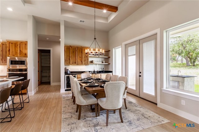 104 Hondo Vis, La Vernia, TX 78121 - dining room featuring wine cooler, french doors, a chandelier, a towering ceiling, and light wood-type flooring