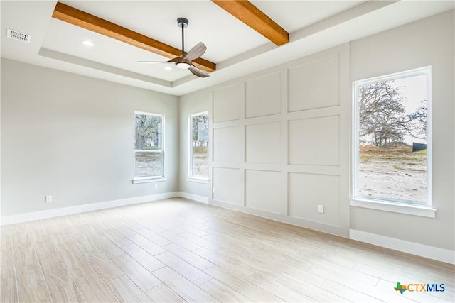 spare room with a raised ceiling, ceiling fan, light hardwood / wood-style flooring, and beamed ceiling