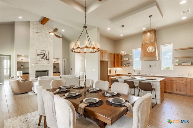 104 Hondo Vis, La Vernia, TX 78121 - dining area featuring light wood finished floors, beamed ceiling, ceiling fan, high vaulted ceiling, and a stone fireplace